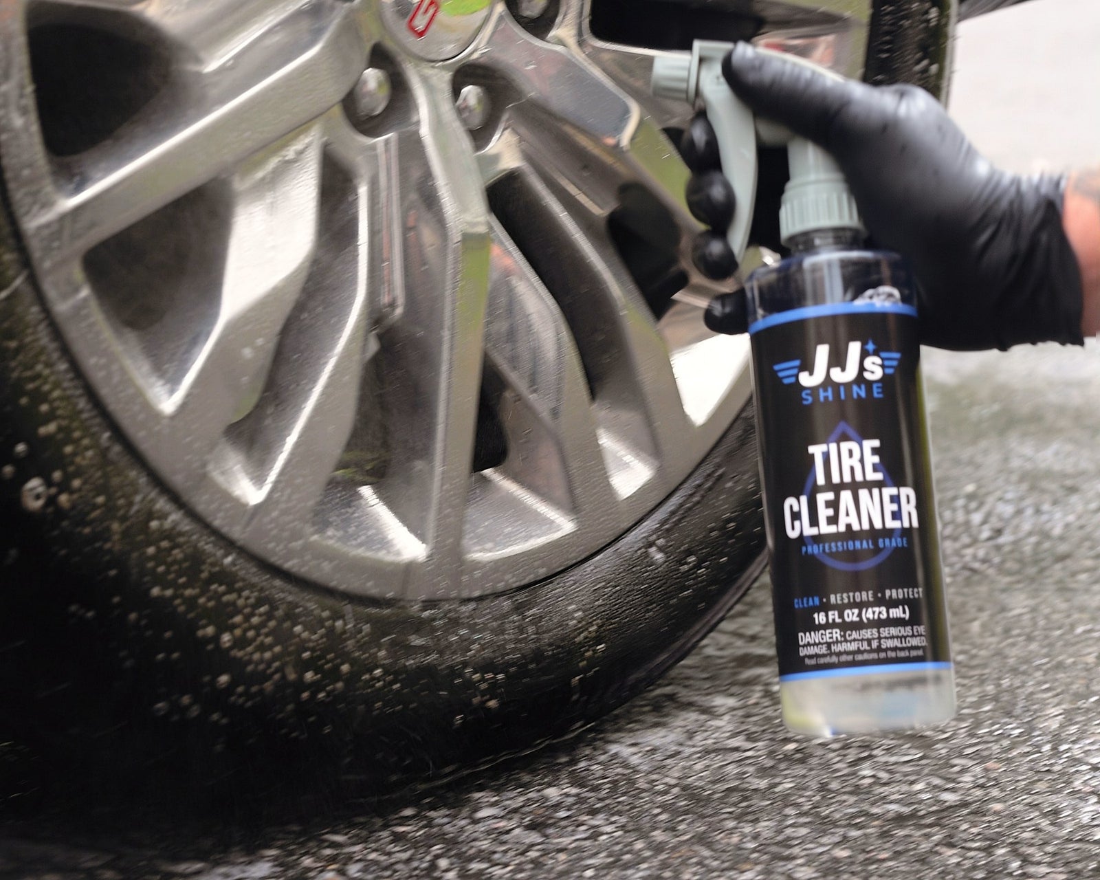JJ's Tire & Wheel Cleaner held at a wet wheel and tire, ready to spray